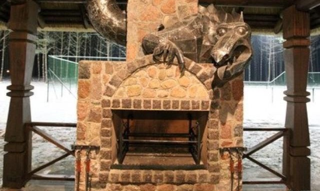 a fireplace with a dragon sculpture curled around the chimney